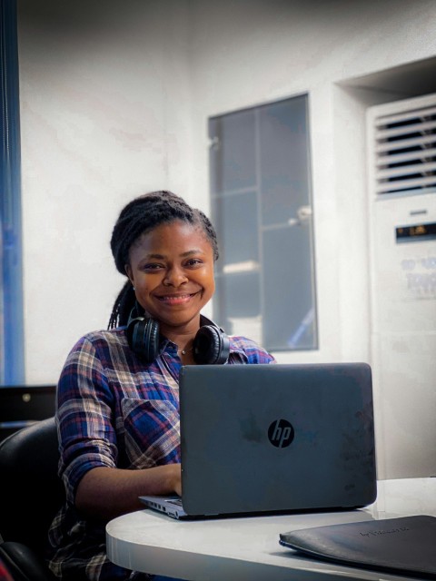 a woman sitting in front of a laptop computer