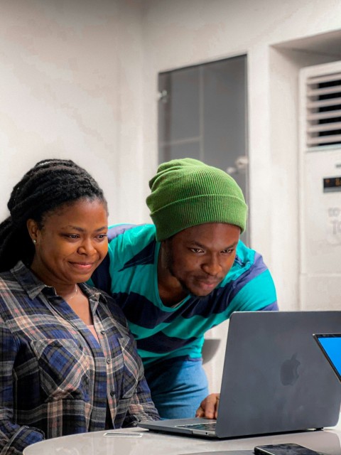 a man and a woman looking at a laptop