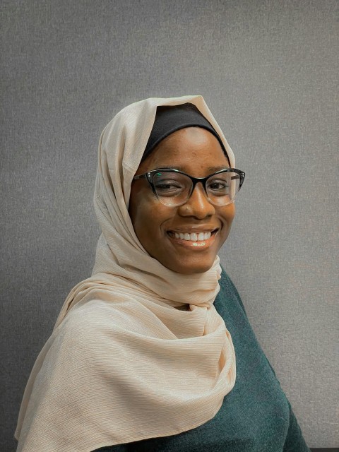 a woman in a headscarf smiles at the camera