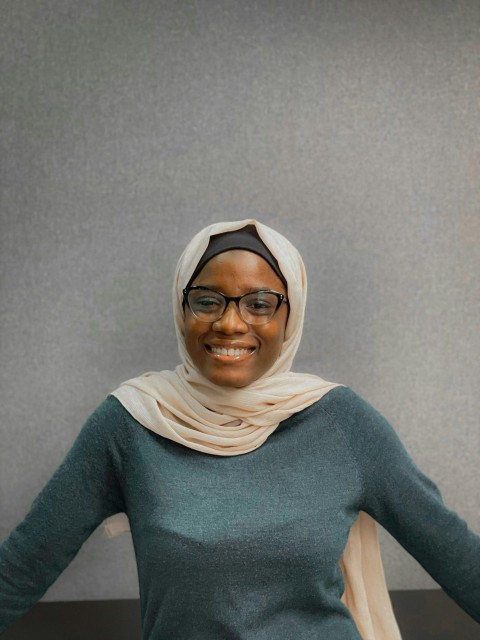 a woman in a headscarf smiles for the camera