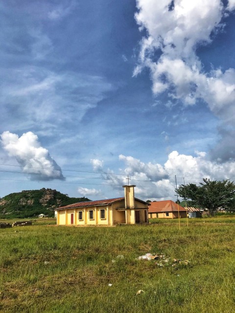 brown concrete building under white clouds and blue sky during daytime