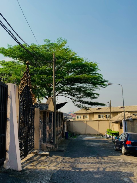 black car parked beside white concrete building during daytime