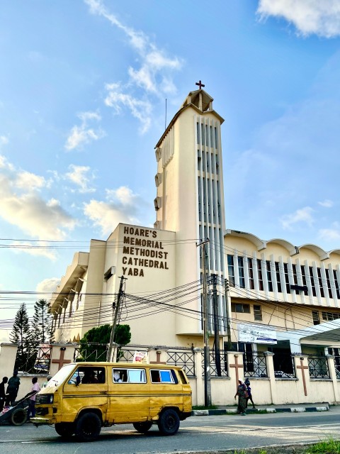 a yellow van parked in front of a tall building xeR