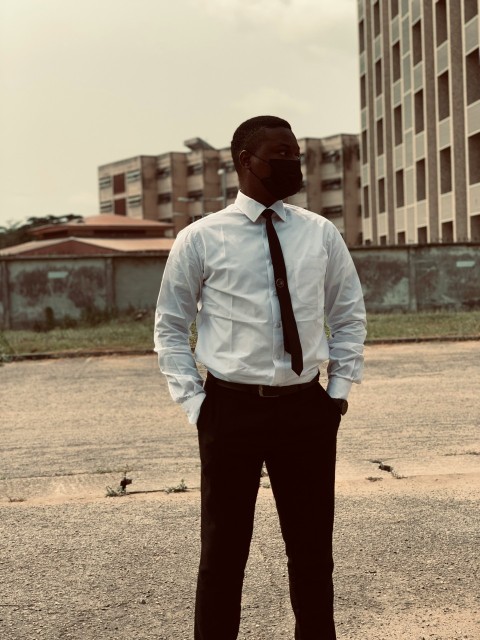 a man in a white shirt and tie standing in a parking lot