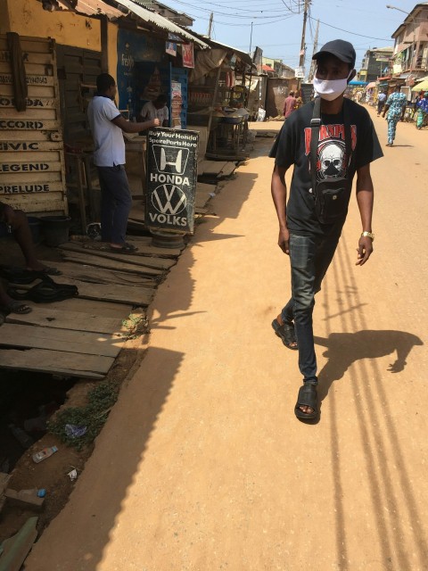 man in black crew neck t shirt and gray pants standing on brown concrete floor during