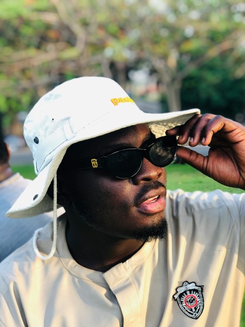 man in white crew neck shirt wearing black sunglasses and white cap