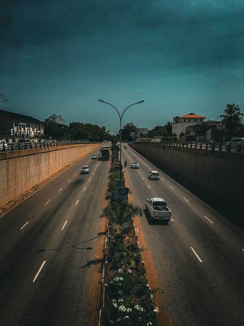 a highway with cars driving down it under a cloudy sky