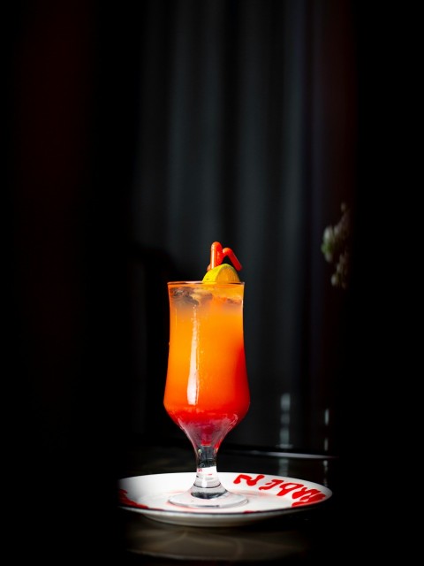 a glass filled with a drink sitting on top of a table