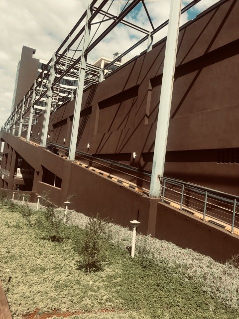 a large brown building with a metal fence around it