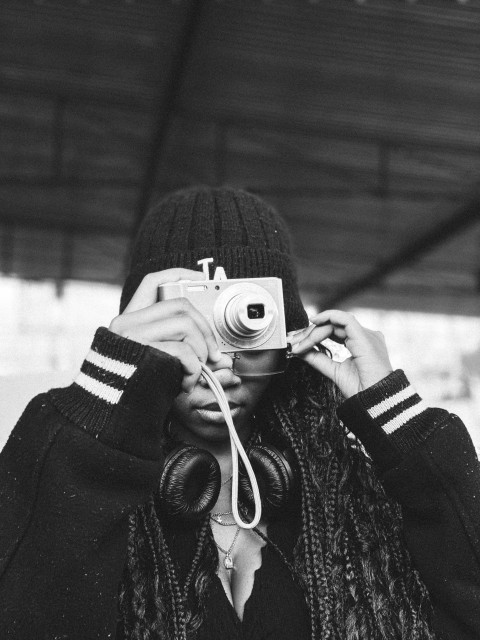 a black and white photo of a person holding a camera