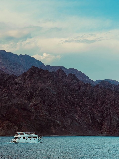 a boat floating on top of a large body of water neW8x