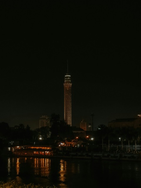 a night view of a city with a clock tower in the background