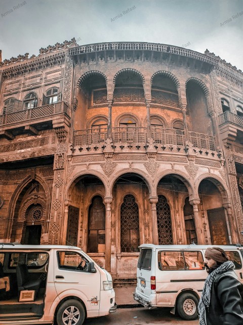 a person standing in front of a building with arches