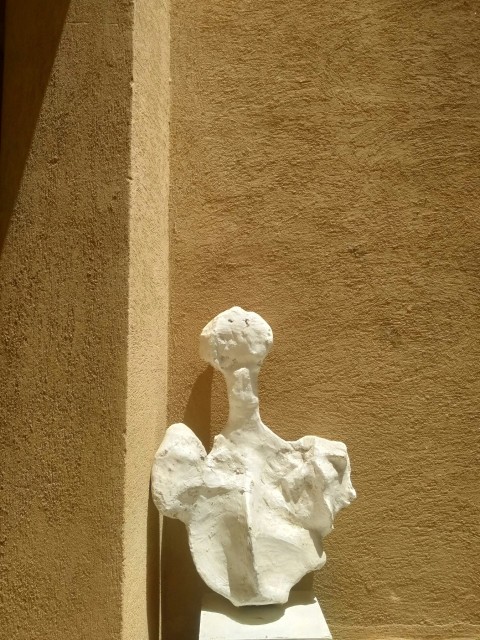 a white sculpture sitting on the side of a building