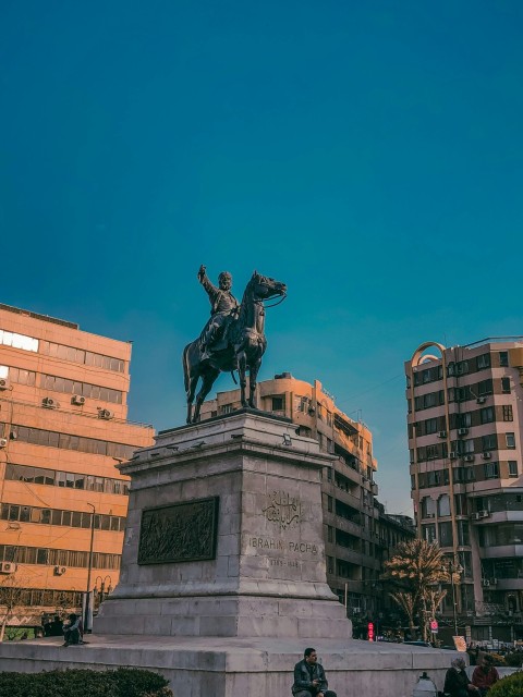 a statue of a man on a horse in front of a building