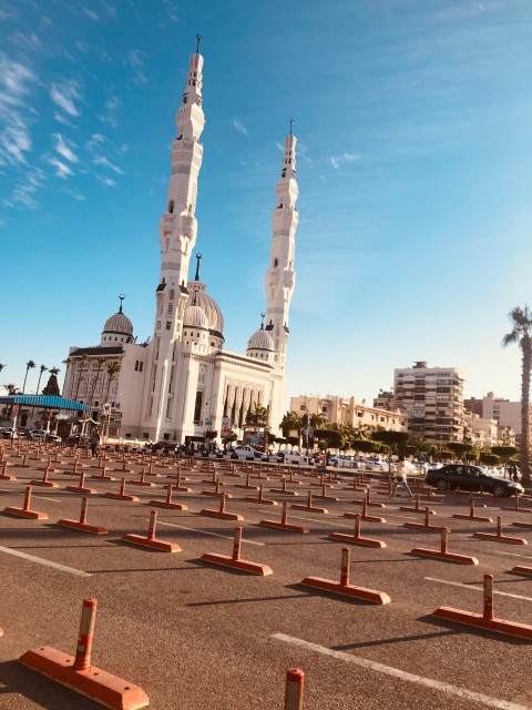 a large white building with two towers in the middle of a parking lot  luBNqla