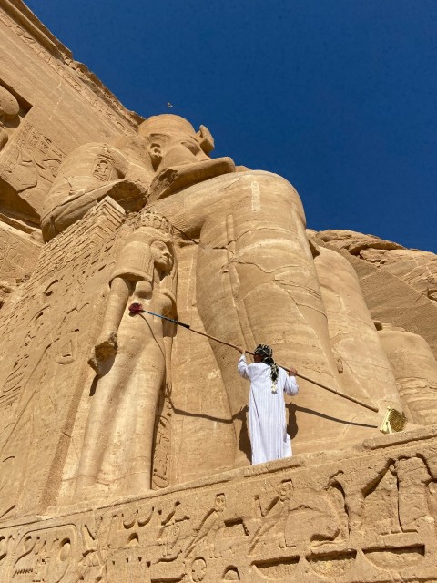 a man in a white robe standing in front of a tall building