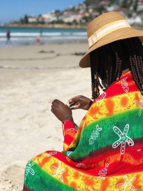 woman in red yellow and green floral dress wearing brown straw hat d4f