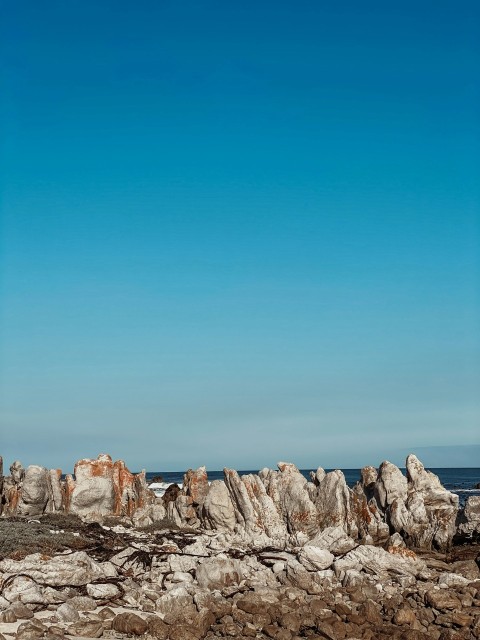 brown rocky mountain near body of water during daytime