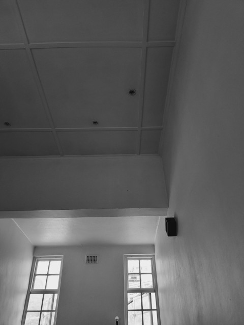 a black and white photo of a room with two windows