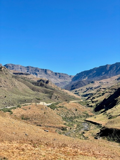 a valley with hills and a blue sky