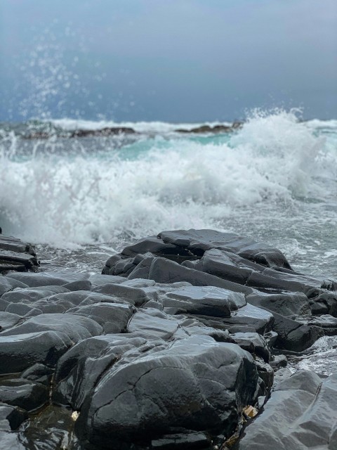 gray rock formation near body of water during daytime