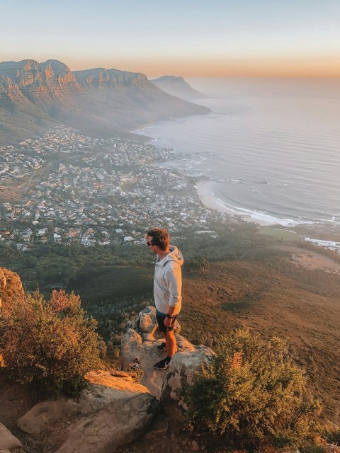 man standing on ledge overlooking town