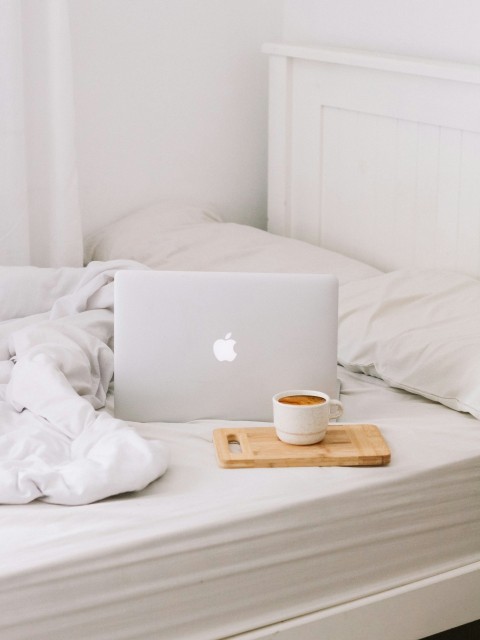 macbook beside teacup with latte