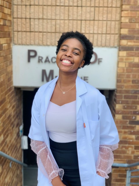 woman in white blazer smiling