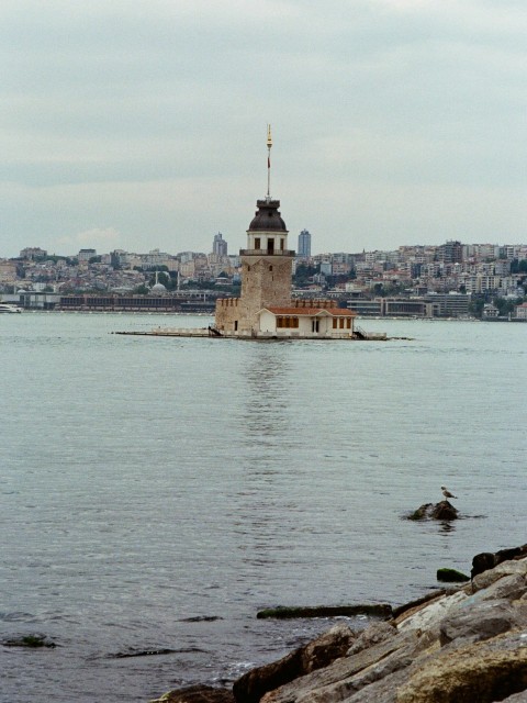 a large body of water with a lighthouse in the background