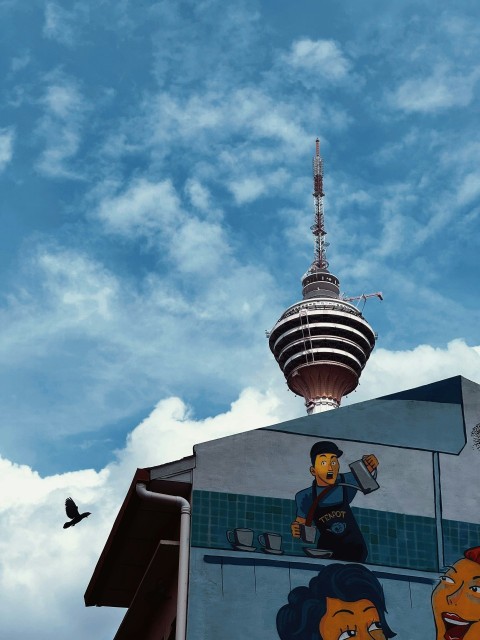 a mural on the side of a building with a tv tower in the background