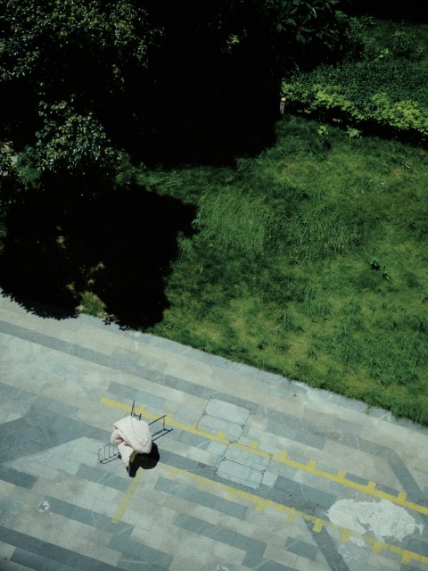 an aerial view of a person walking down a sidewalk