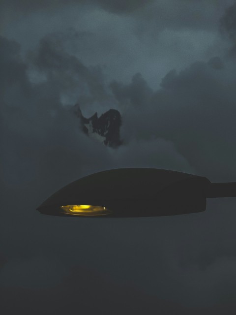 a large object flying through a cloudy sky 90A