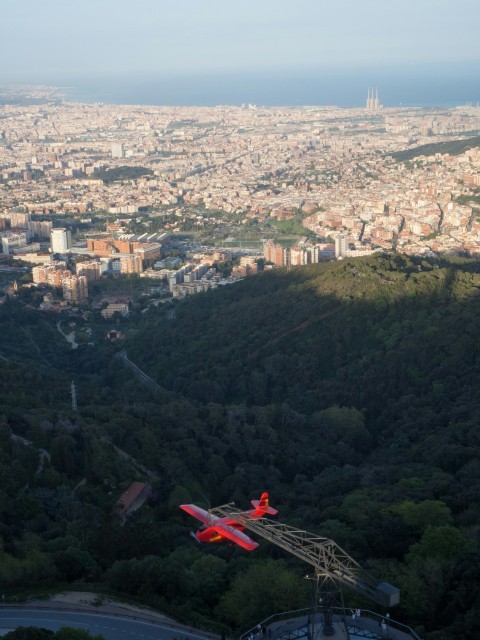 a plane flying over a city with a mountain in the background