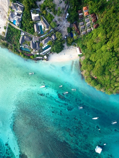 an aerial view of a beach with boats in the water