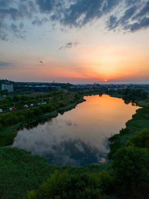 the sun is setting over a small river