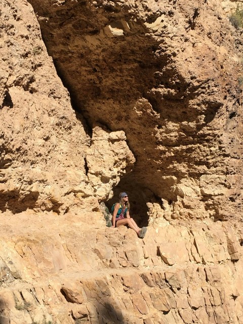 a person sitting on a rock in a cave