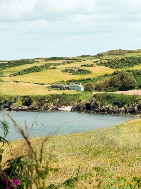 a large body of water surrounded by lush green hills