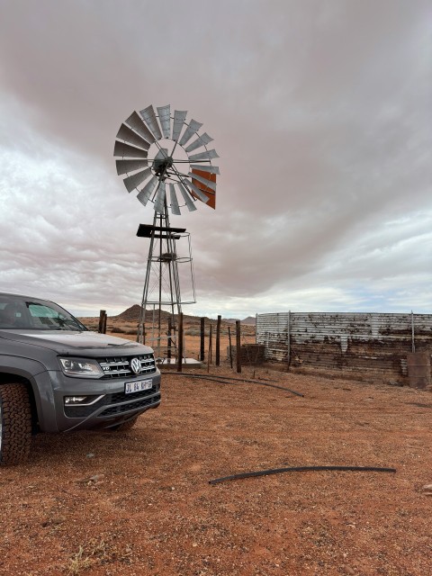 a truck parked in front of a windmill