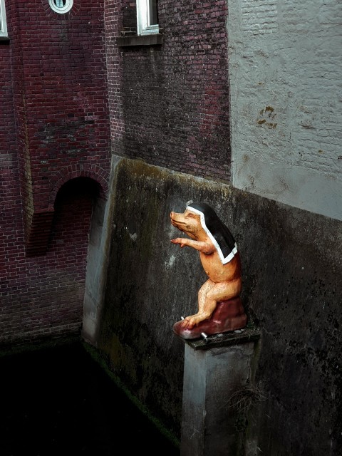 a small statue of a man on a pedestal next to a building