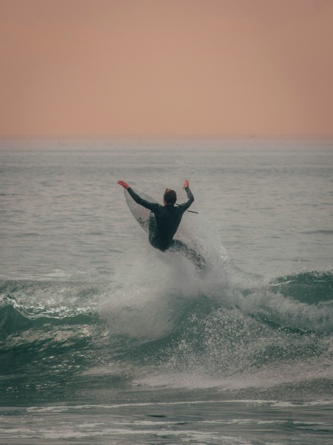 man surfing on sea waves during daytime