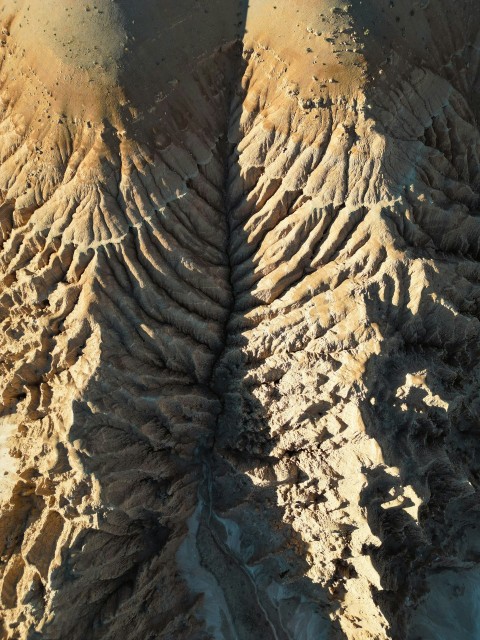 an aerial view of a desert landscape with sand and rocks