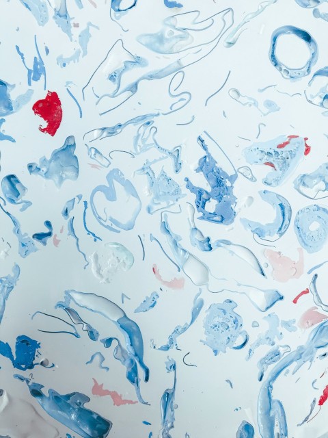 a close up of a painting with blue and red paint