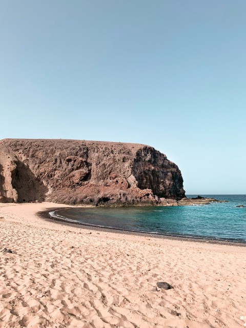 brown rock formation on blue sea under blue sky during daytime
