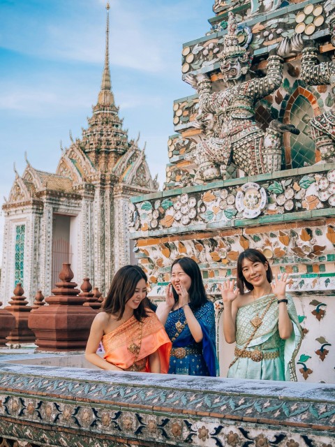 two women standing next to each other in front of a building