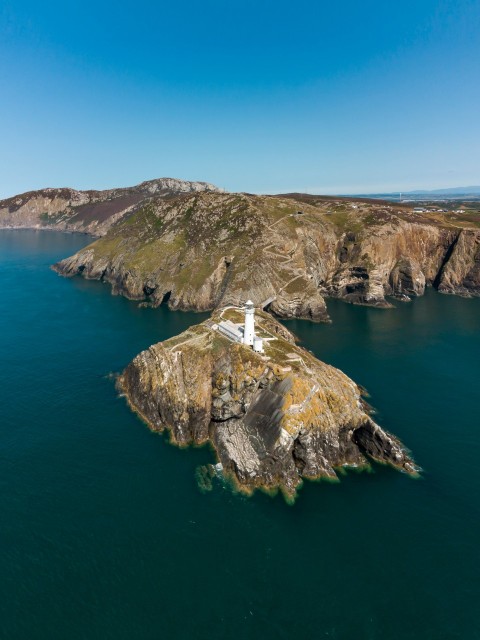 a lighthouse on a small island in the middle of the ocean