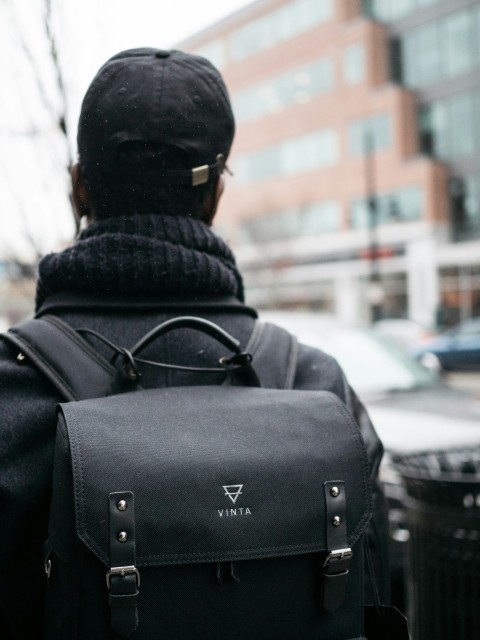 man wearing black top hat and vinta backpack selective focus photography