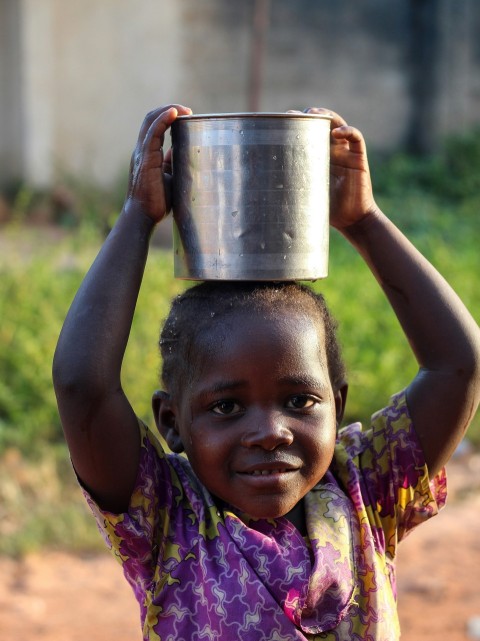 a young girl carrying a bucket