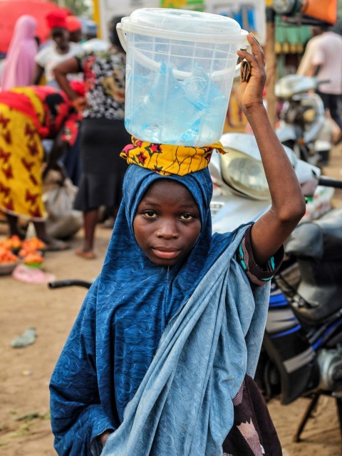 a person carrying a large plastic bag on the head