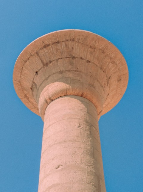 a tall tower with a bird perched on top of it